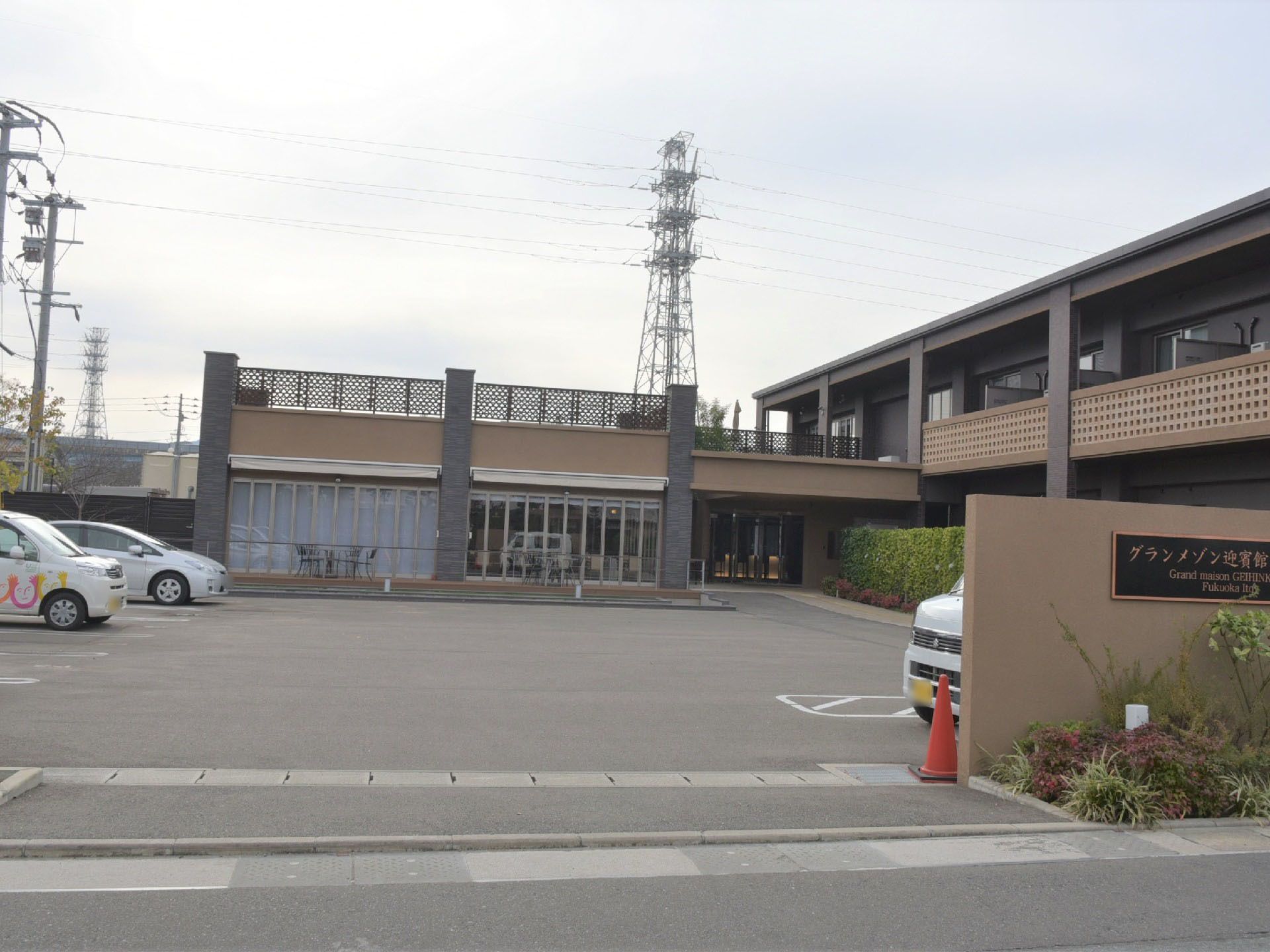ブラウンを基調とした落ち着いた雰囲気の建物で、2階建てになっています。駐車場も十分あり、広々としています。