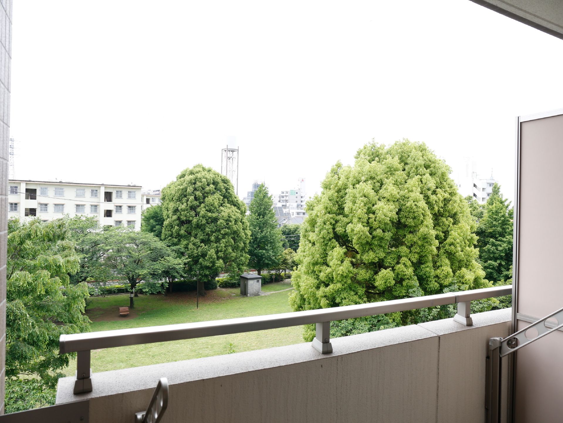 ベランダを出てみると、芝生の広場が見えます。木々がたくさん植えられていて、自然を感じることができます。