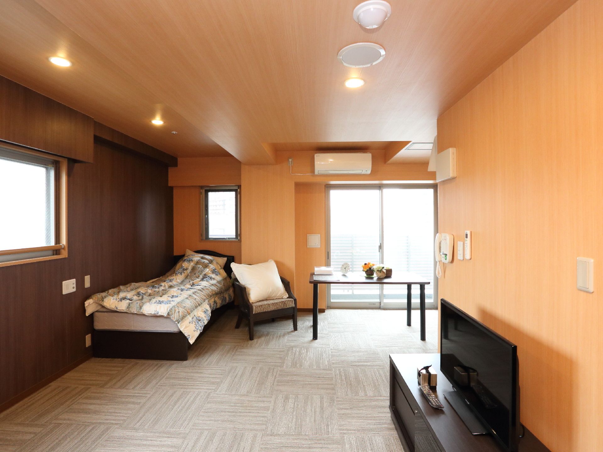 お部屋の壁と天井は木目調になっていて、落ち着いた雰囲気。複数ある窓からは明るい日差しが入り、快適に過ごせる。