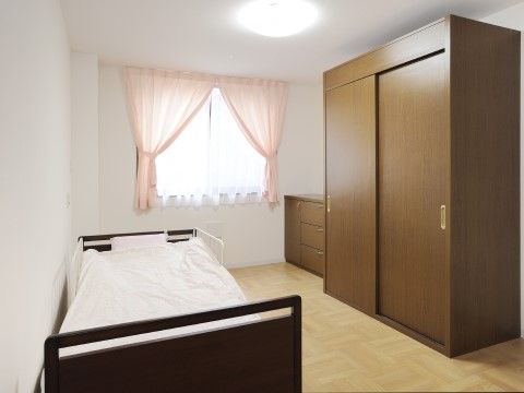 右壁面に大型のクローゼットが設けられ、左の壁面にベッドが置かれた居室