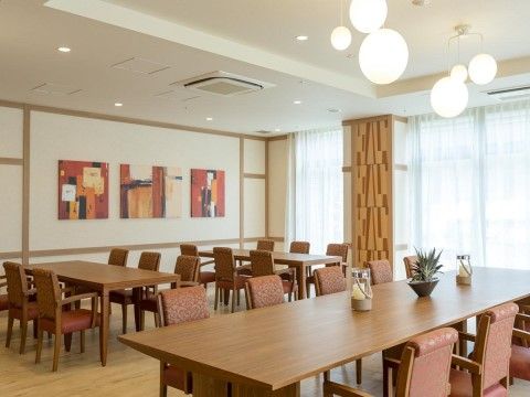 レストランは、天井から丸いペンダントライトが下がり、壁には絵が飾られている。テーブルや椅子は落ち着いた雰囲気である。