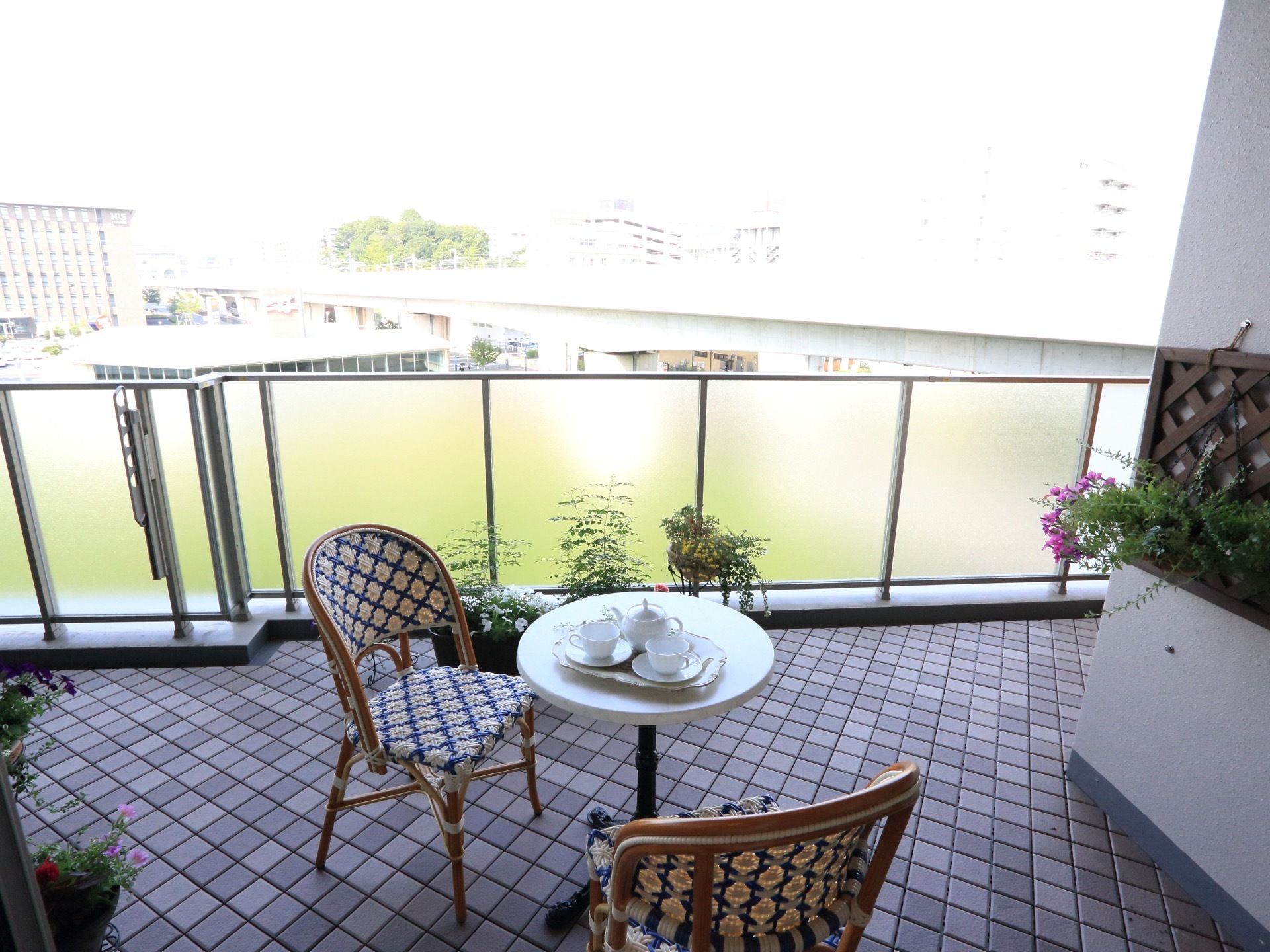広々とした屋外のテラスになっている。ゆっくりと過ごせる椅子とテーブルが用意されている。不透明のフェンスも取りつけられている。