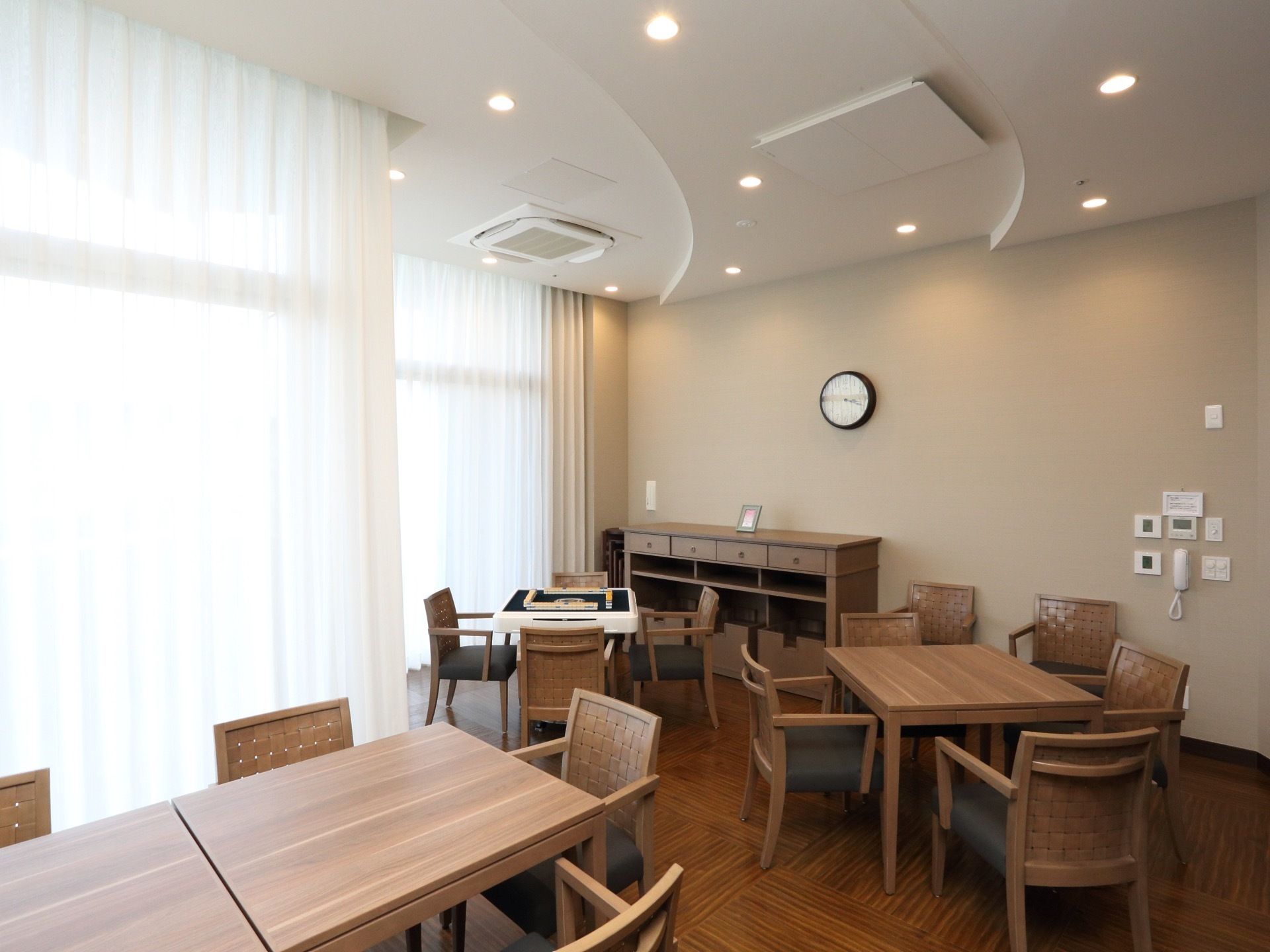 木目調の家具で統一された室内。４名様、６名様用にテーブルが配置され、麻雀がお楽しみいただけるようになっている。