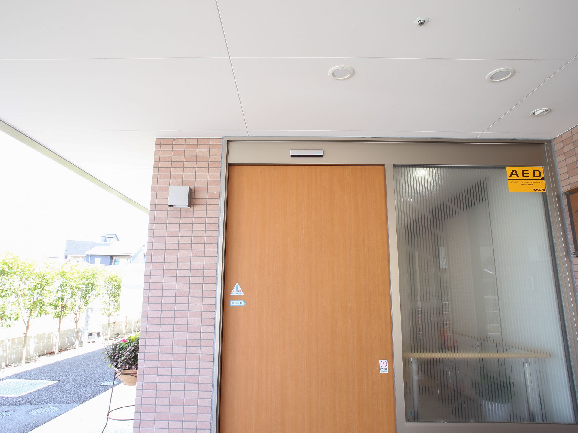 施設入口の扉は、木製の自動ドアである。右隣はすりガラスになっている。玄関上には、天井屋根がついている。