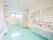 水色の床が印象的なトイレである。壁に手すりがある他、男性用小便器や洗面所の両脇に手すりが備わっている。