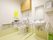 広々としたトイレは、便器の両側に可動式の手すりを設置しており安全に利用できる。温水洗浄便座で、操作ボタンが壁にあり便利である。