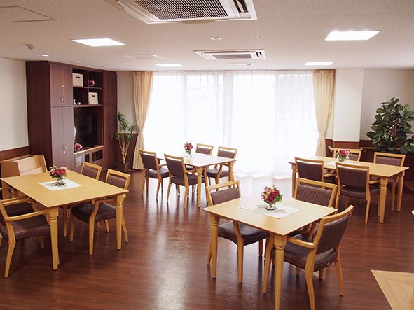 空調が完備されている広い部屋。６人掛けのテーブルセットが並んでいる。窓際にはソファ席もある。テレビが設置されている。