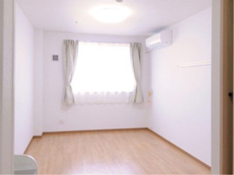 白にフローリングの内装、右の壁面の上部にエアコンが設けられた居室