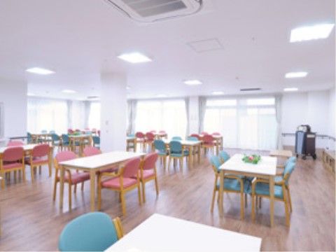 4人掛けのテーブルが多く配置されており、ピンクと青の椅子が並べられている。椅子はひじ掛けでゆったりと座ることができる。