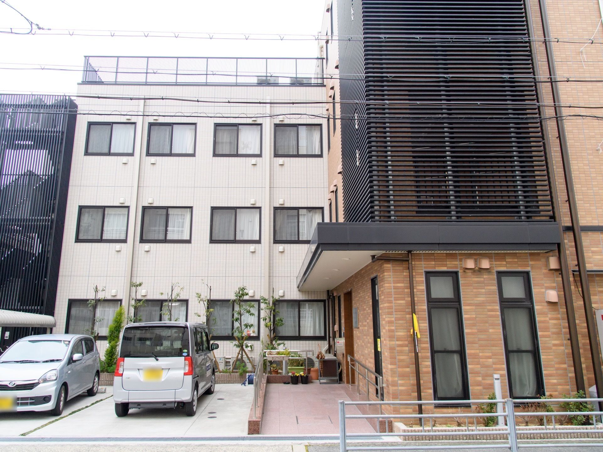 レンガ調の外壁で、丈夫なコンクリートづくりの４階建ての建物。庭には花と樹木が植えられなごませてくれる。