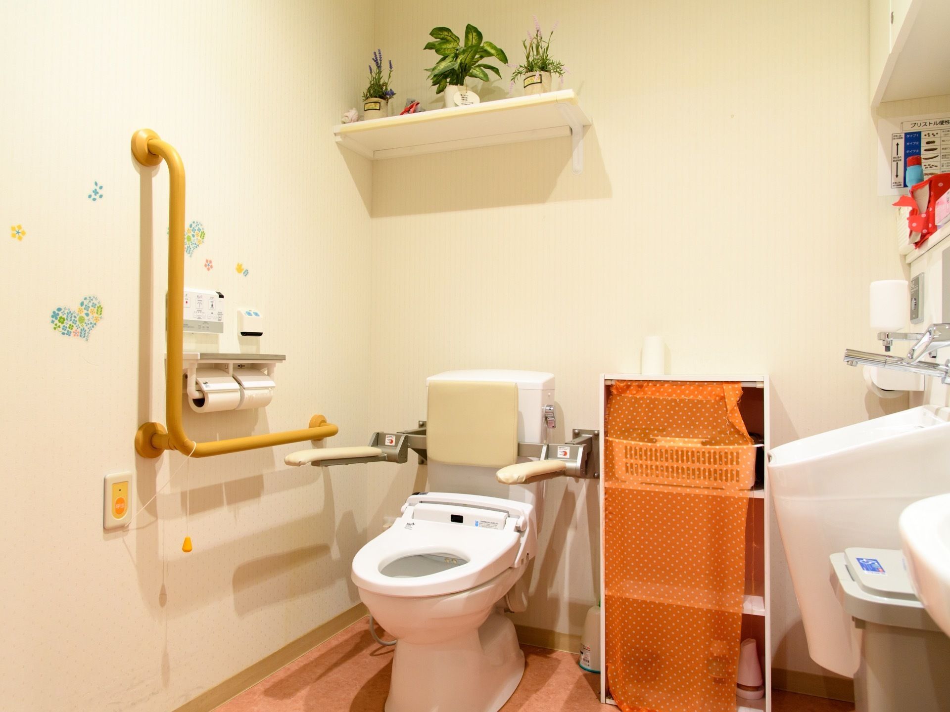 トイレは広く介助用器具がつけられている。オストメイトにも対応している。白を基調とした室内は、装飾があり明るい雰囲気がある。