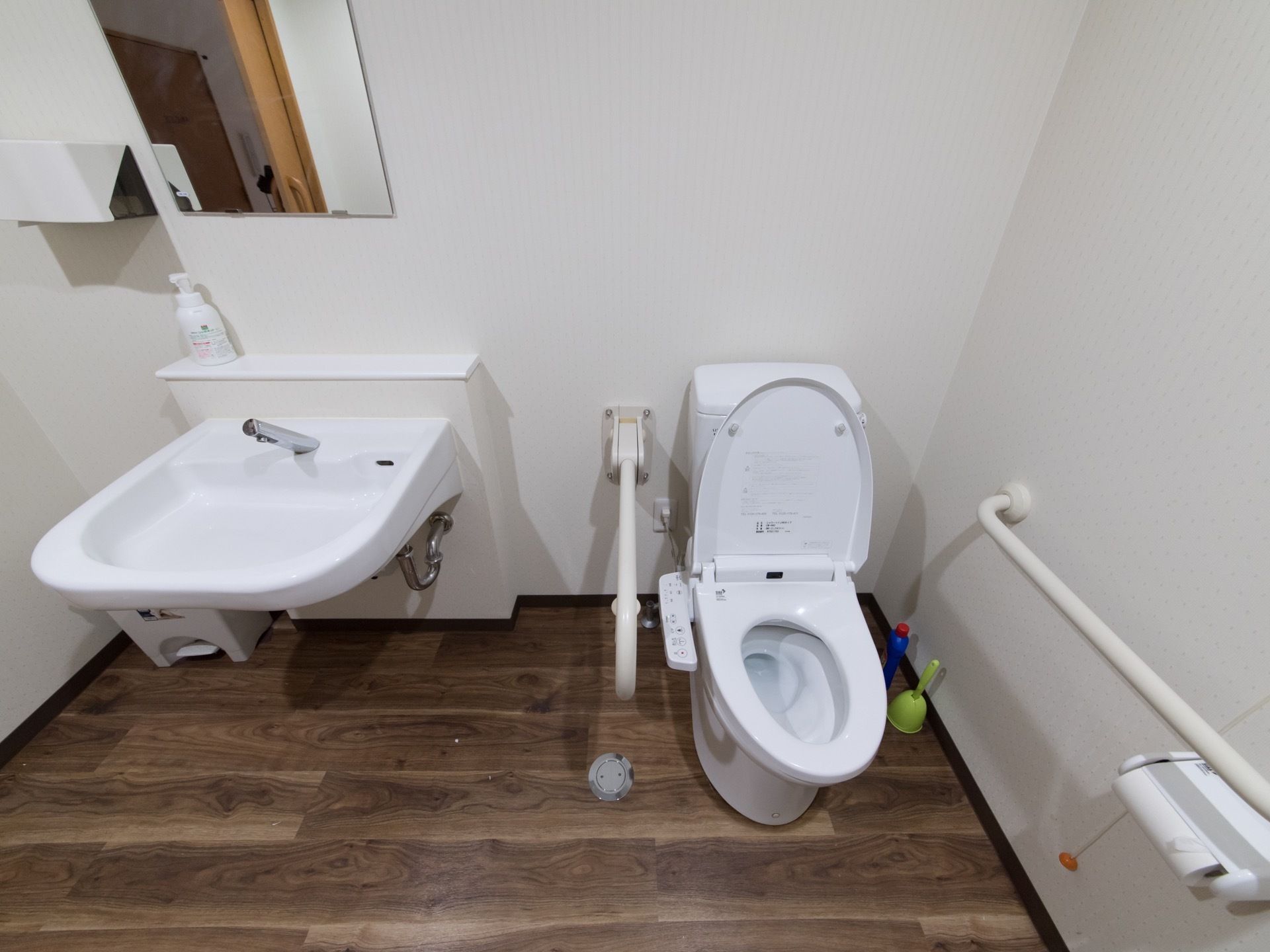 広々としたトイレは、清潔感あふれている。両側に手すりがあり、安全に移動できる。緊急呼出ボタンの紐もあり、何かあればすぐ対応できる。