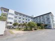 白い４階建ての鉄筋コンクリート造りの建物である。敷地内には大きなたくさんの樹木が整然と植えられている。