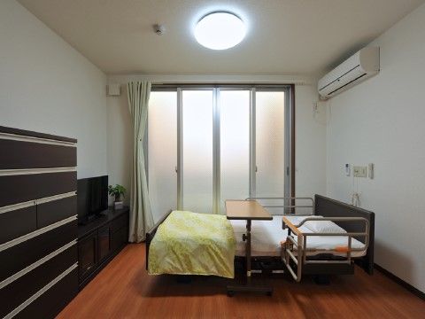 テレビやチェスト、ベッドが設置された居室