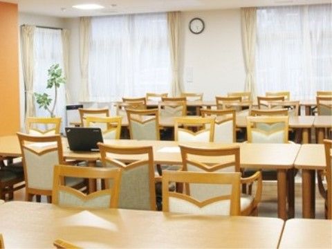 椅子がセットされたテーブルが横に何列か並べられた食堂