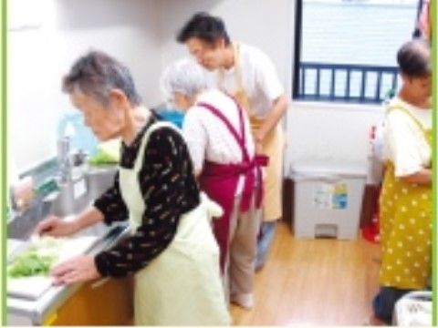 台所に立って調理をしているエプロンをかけた4人の高齢女性