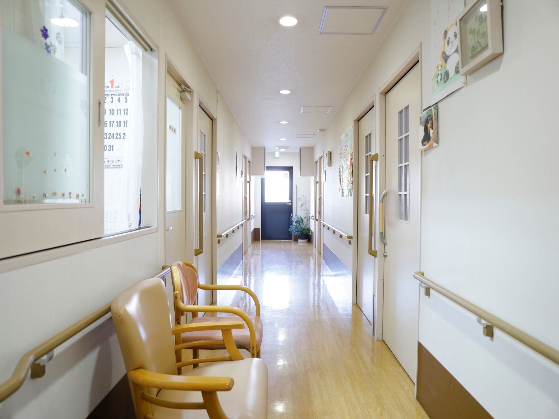 通路の床は全面フラットなフローリングである。壁には手すりを設置し、休憩用にひじ掛け付きの椅子を用意している。