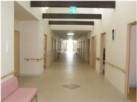 一番奥から光が差し込む、両側にドアが並んでいる廊下