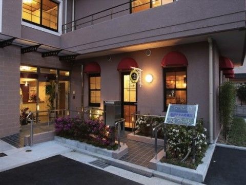 外国のレストランやホテルを思わせる、おしゃれな外観の建物である。入り口前には花壇、車椅子用のスロープもある。
