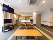 木製のテーブルと椅子がある。カウンターキッチンになっており、テーブルの上には小さなテレビを置いている。