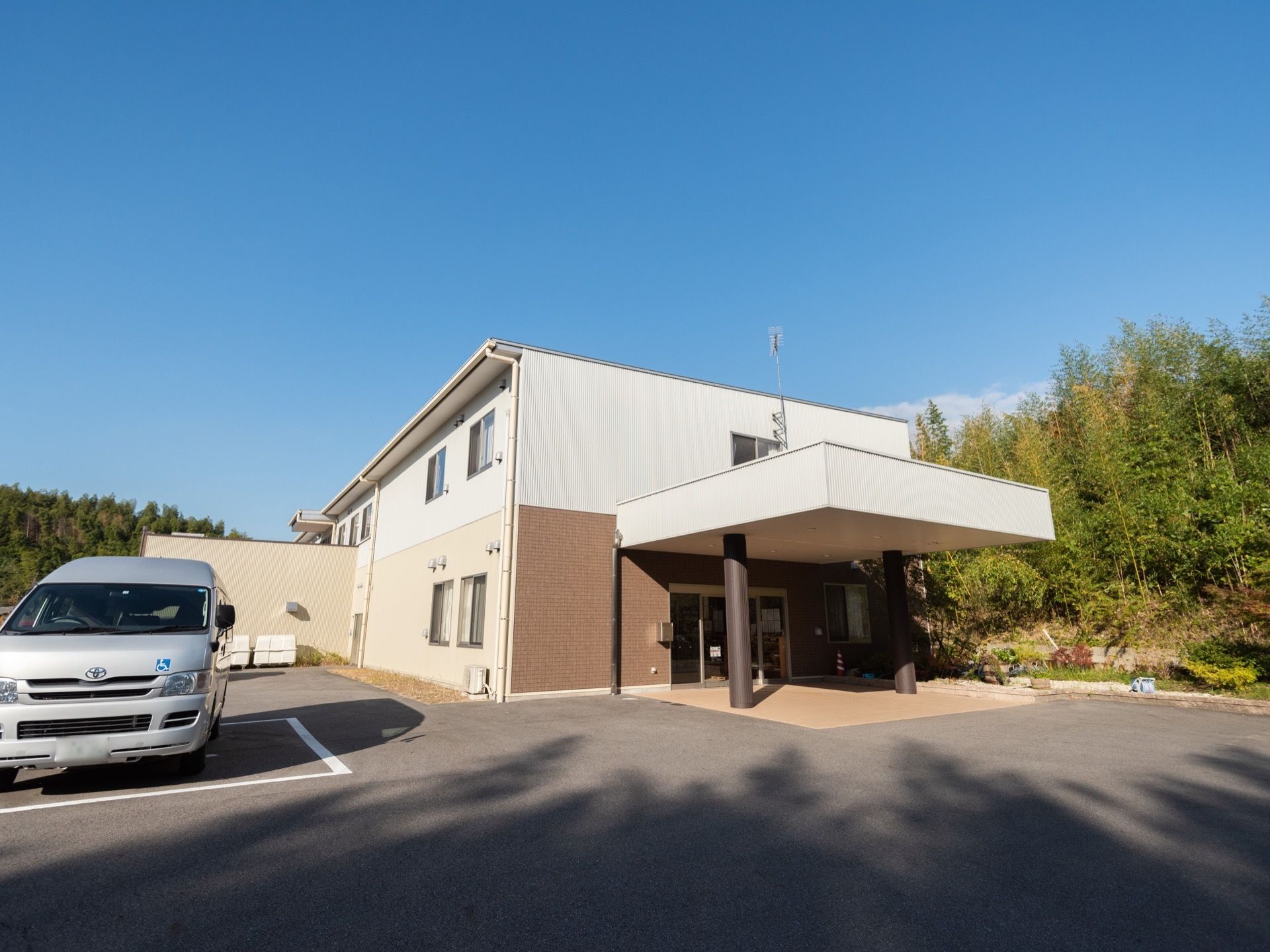 ホワイトとクリーム色、ブラウン使った2階建ての施設建物である。ブラウンの太い柱2本で支えられた大きな玄関屋根が特徴的である。