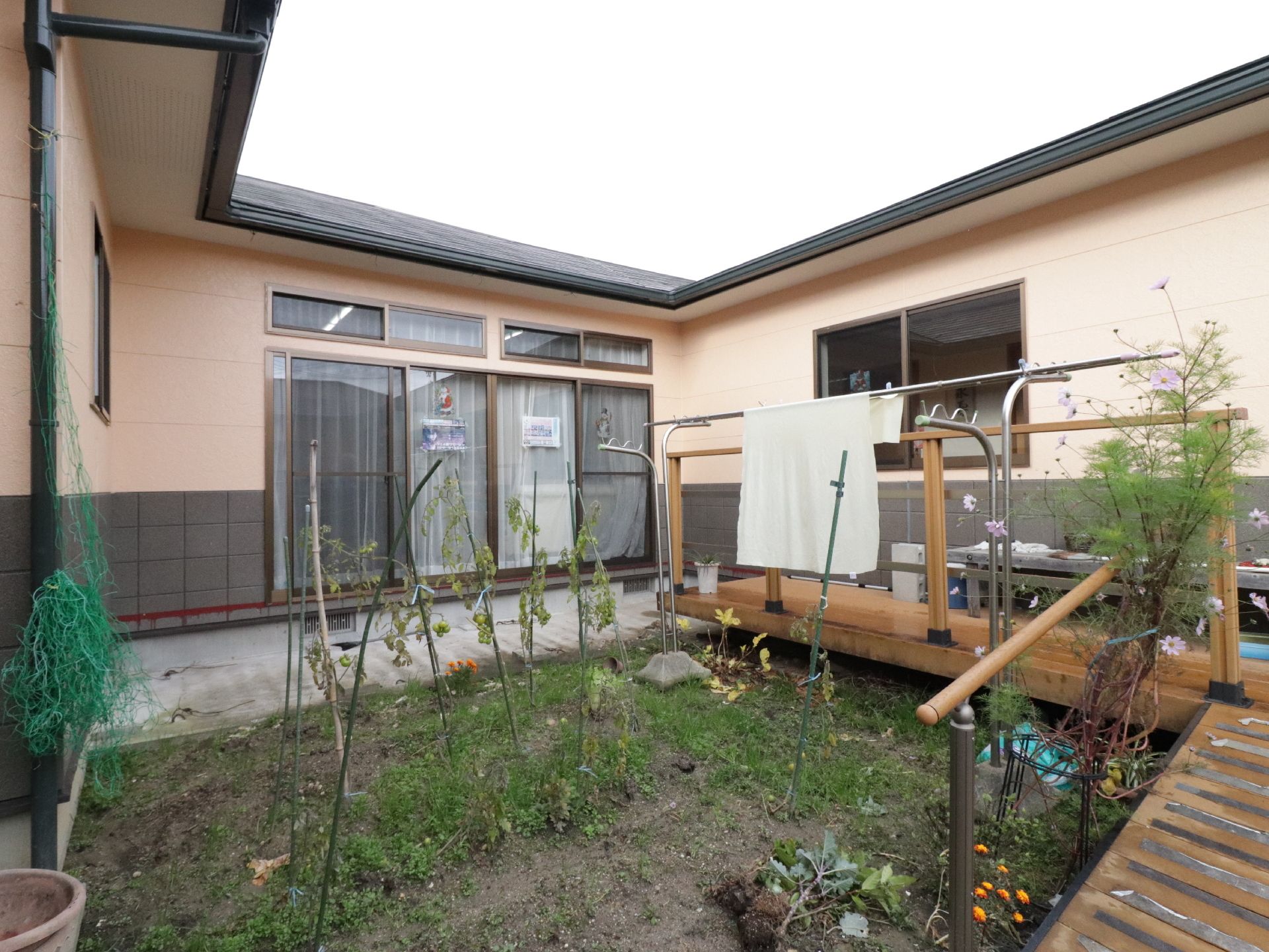 左に物干し場、中央に小さな畑のある、周りを建物に囲まれたスペース