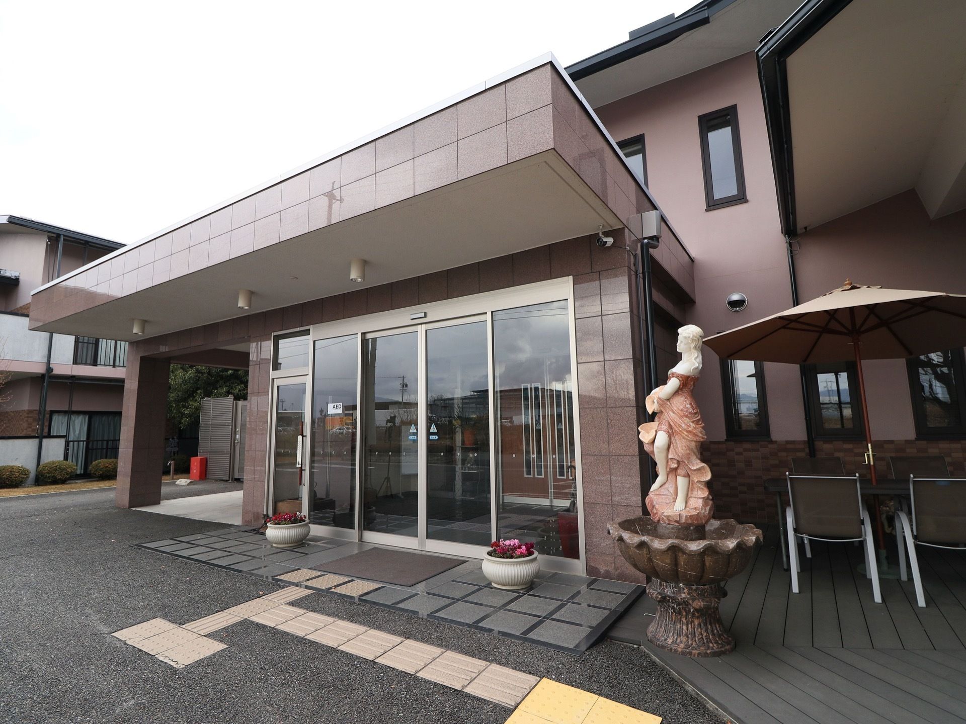 段差のない間口の広い自動扉になっている。ガラス張りになっており、館内の様子をうかがうことができる。植木鉢や彫刻が置かれている。