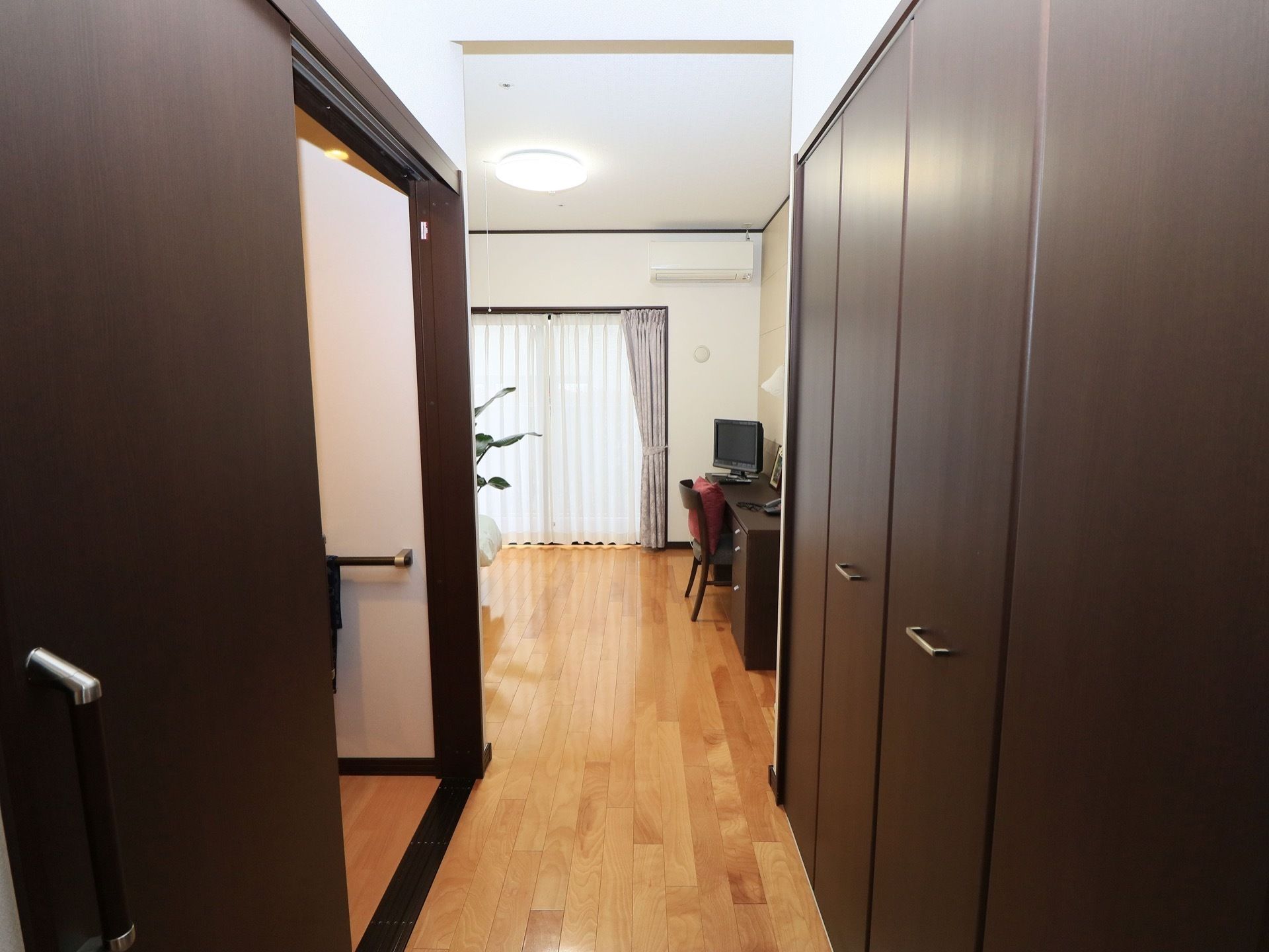 大きな収納スペースが確保されており、向かい側にトイレがある。エアコンとテレビが完備されている。大きな窓がある。