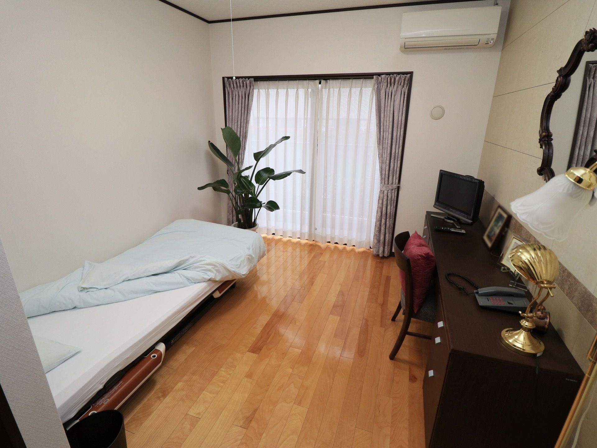 おかずや小鉢が並んだテーブルについて、二人で食事をする高齢者の男女
