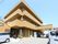 茶色い壁の３階建ての建物である。窓にはベランダが設置されている。玄関前は大きなルーフで覆われ、周囲には車が数台停まっている。