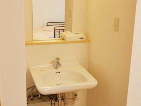 洗面台は下に足が入るので、車椅子をご利用の方も使いやすい。鏡のところには、タオルなど小物を置くことができる。