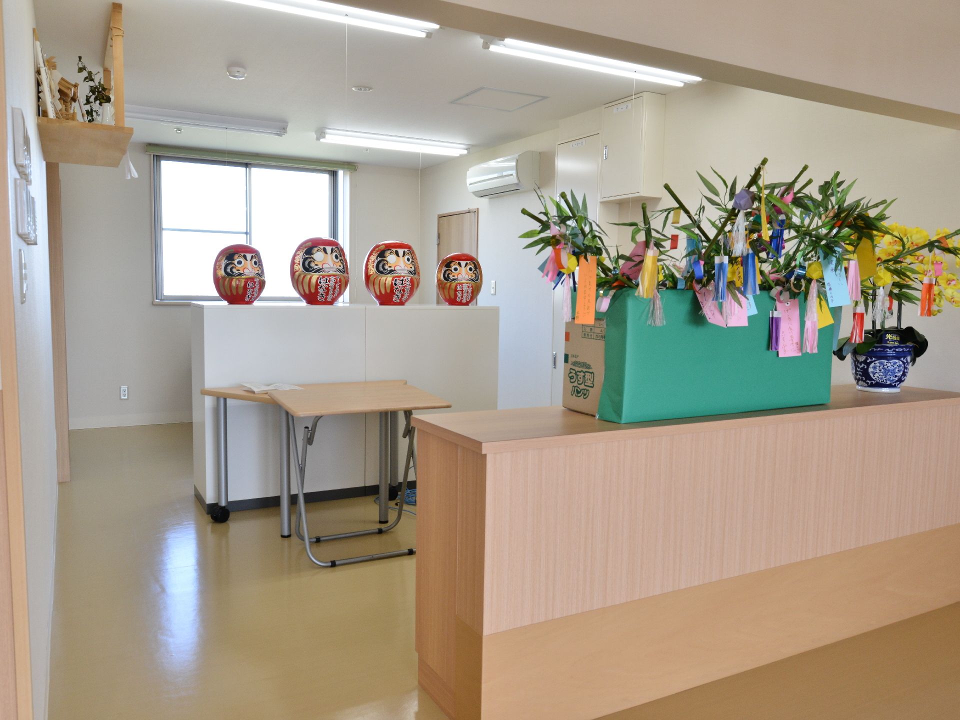 神棚が設置され、お祈りをすることもできる。棚にはだるまがいくつか飾られている。短冊がつるされた笹が飾られている。