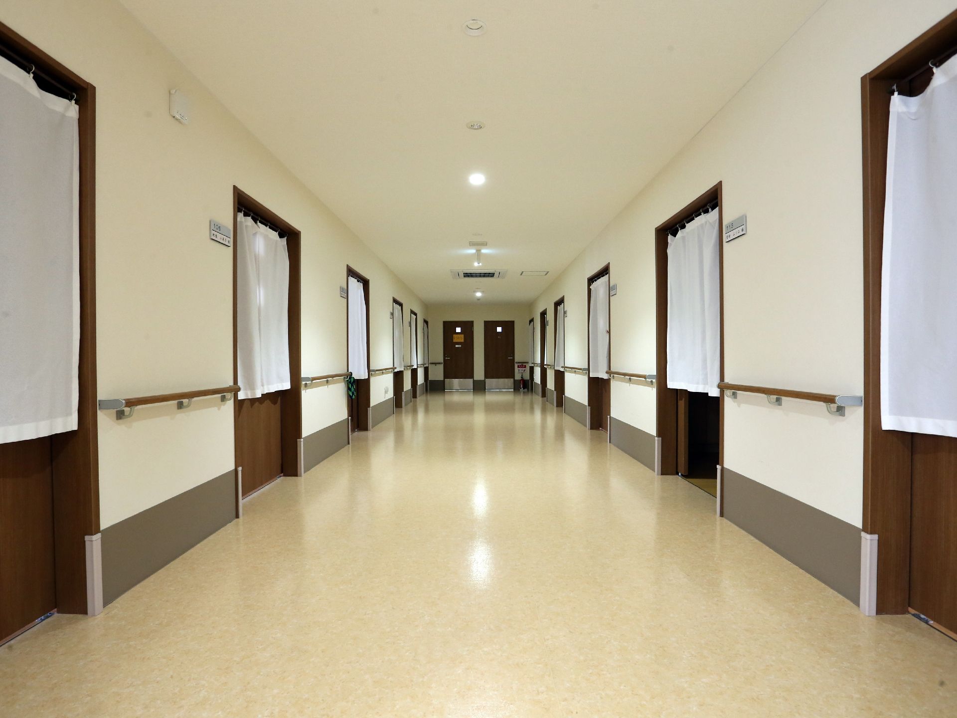 利用者の個室は、広い廊下に並んでおり、ドアは引き戸で安全面にも配慮されている。ドアの前のカーテンでプライバシーを守ることができる。