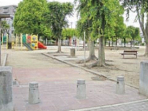 背の高い木が何本も生えていて、遊具が置かれている公園