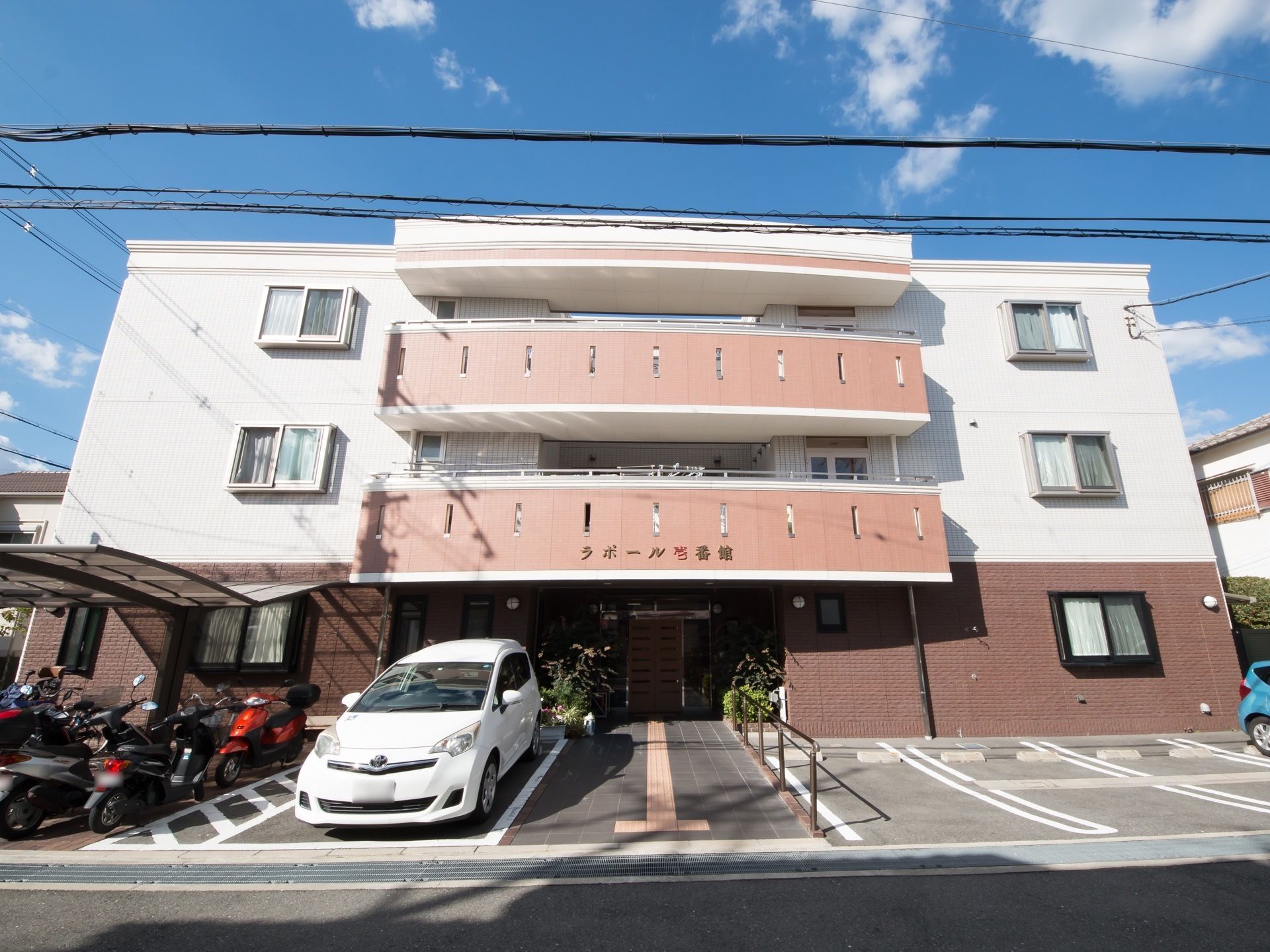 正面玄関までの短い通路を中心として、左右に駐車用スペースを配置してある。さらに左は駐輪場となっている。
