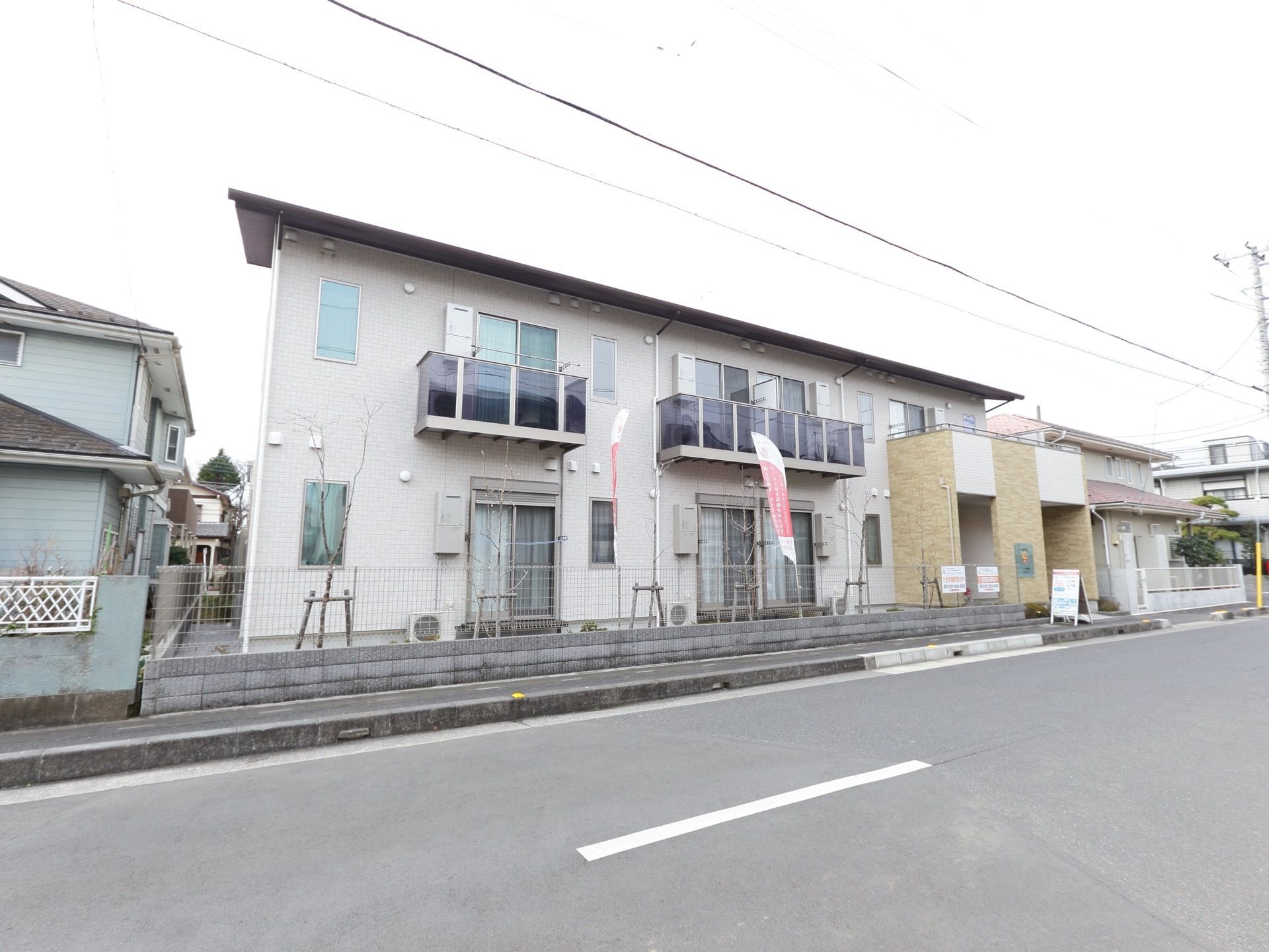 車道に沿うように建っている、アパートのような２階建ての建物が施設である。２階の部屋にもバルコニーがついている。