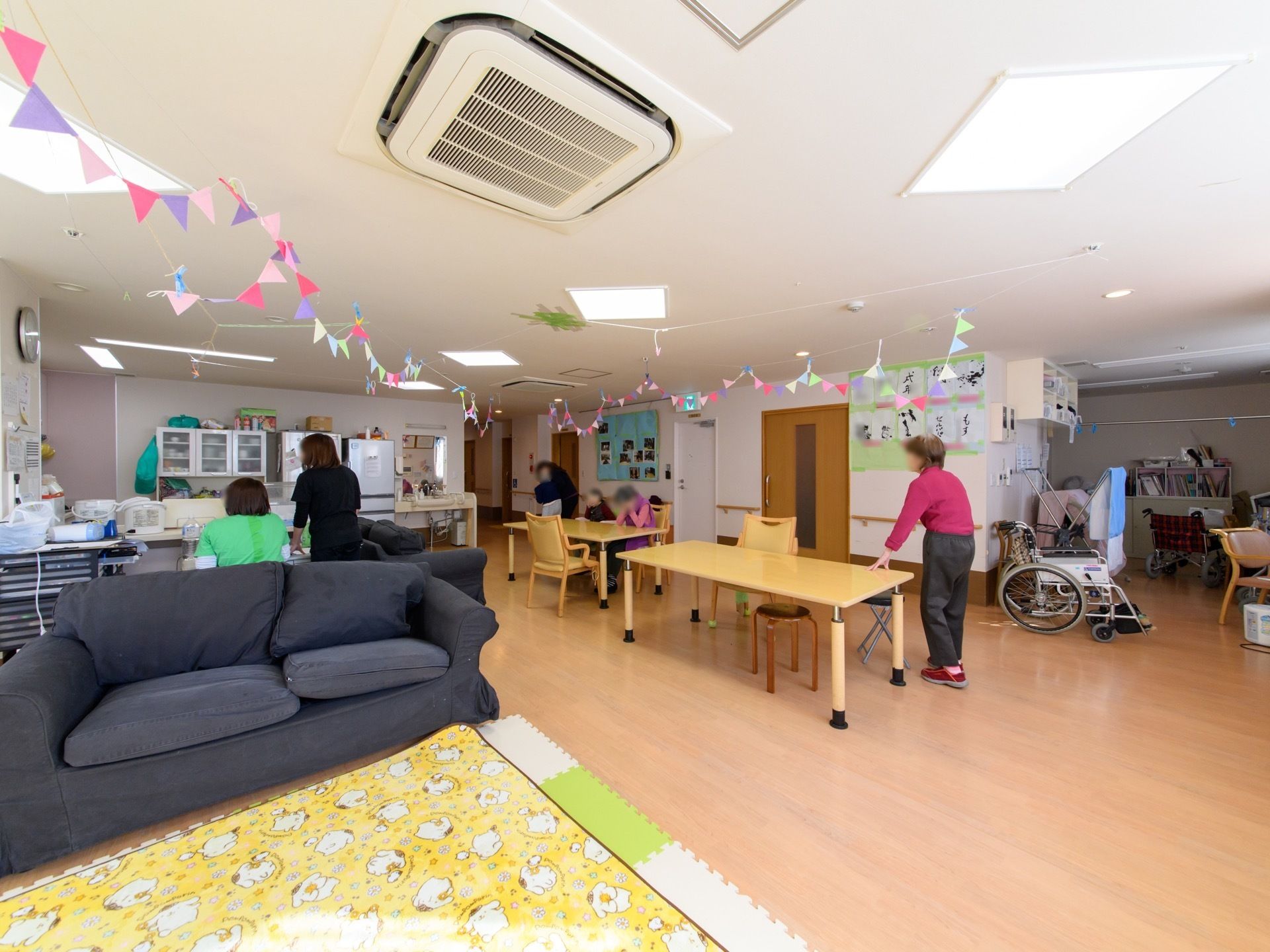 広々とした部屋である。テーブルやソファーが設置されている。部屋の奥にはキッチンがあり、冷蔵庫や食器棚がある。
