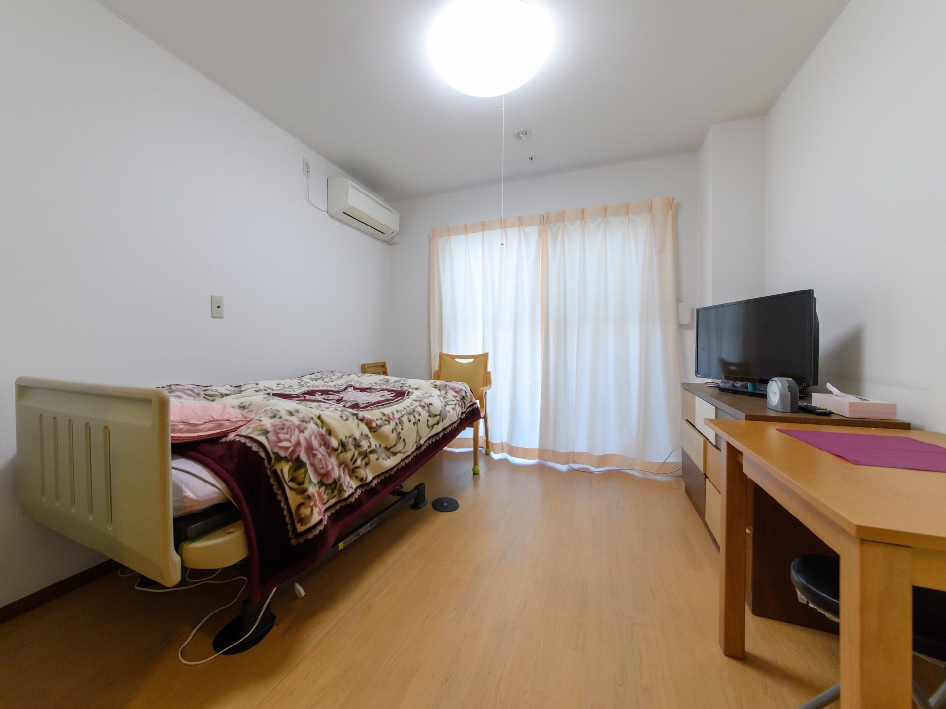 広々とした、白が基調の部屋には、大きな窓があり、電動ベッドも完備している。エアコンがベッドに直風にならない位置についている。