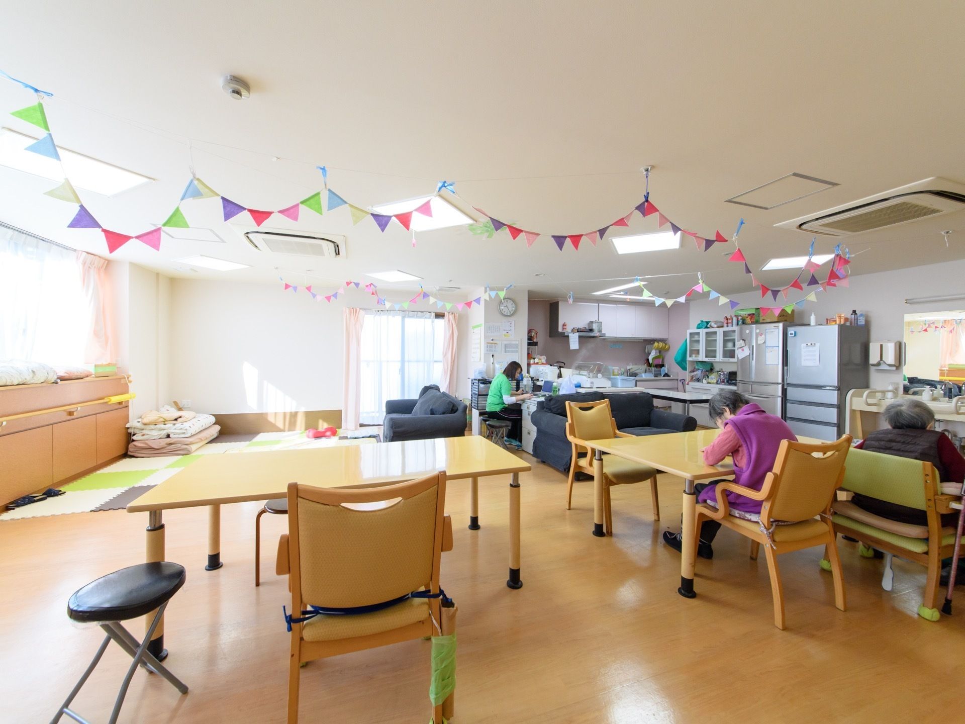 大きな窓から日の光がさす部屋である。とても大きく白基調のフローリングの部屋で、シンクや冷蔵庫も備わっている。