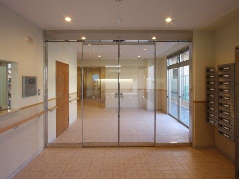 左に受付、右にポストが並んでいる自動ドアのエントランス