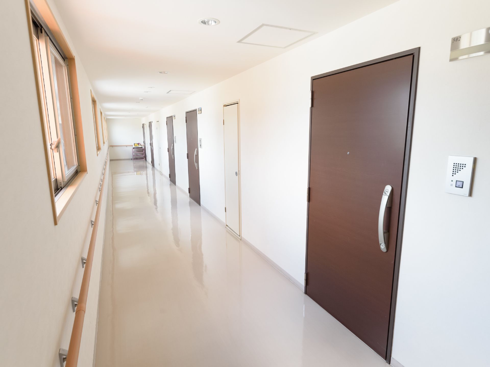 共用廊下に並ぶ入居者様の居室の出入口にはインターホンがある。来訪者様が訪れた際にはこちらで対応を受けることができる。