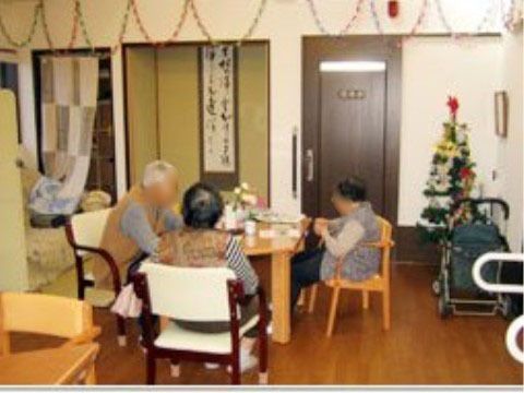 クリスマスの飾り付けがあるリビングで、テーブルに向かって座る三人の入居者様