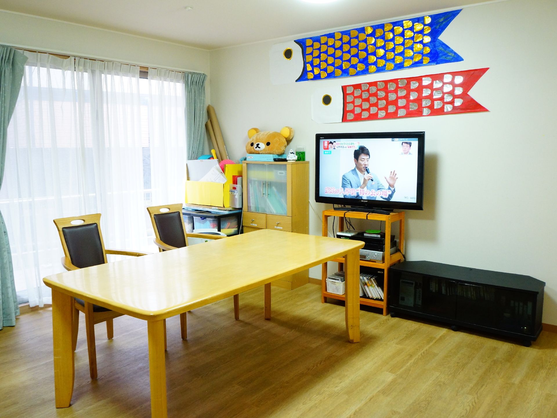 左手の窓からは明るい日差しが差し込んでいる。壁には鯉のぼりのオブジェが貼られ大きめのテーブルと椅子が用意されている。