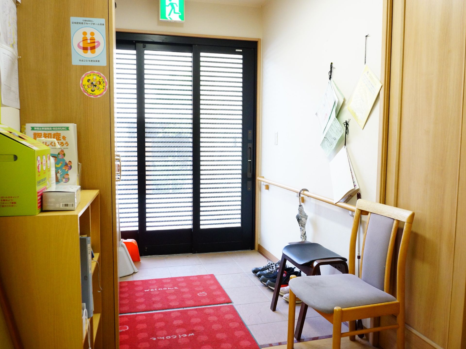 玄関はバリアフリーで外とつながっている。玄関の扉は3枚で出来ており左手には木製の棚が設置されている。