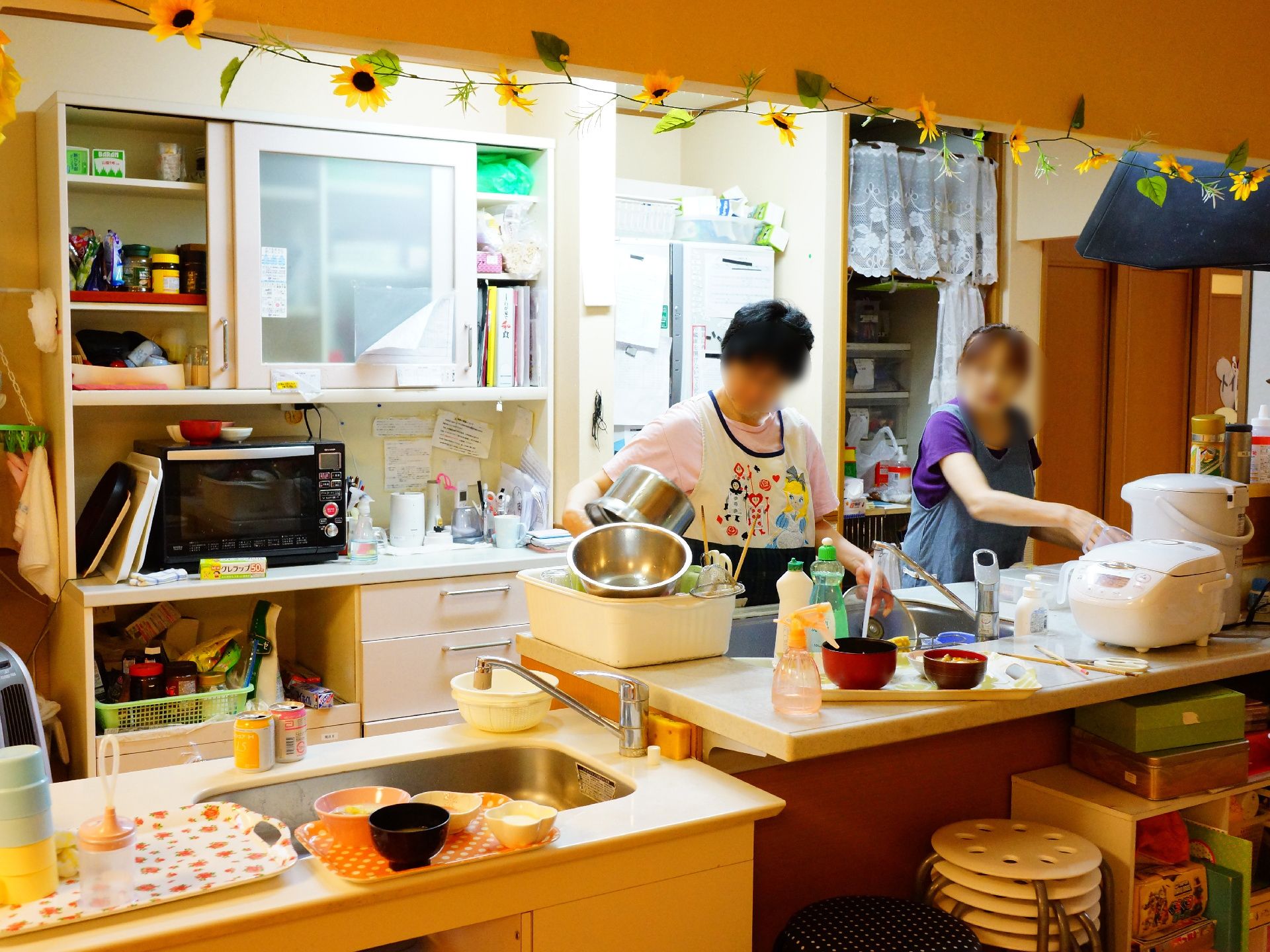 調理家電や調味料がたくさん揃っているキッチンで料理をする二人のスタッフ