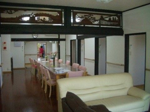 部屋の中央に欄間が取り付けられている、ソファとダイニングテーブルのあるリビング