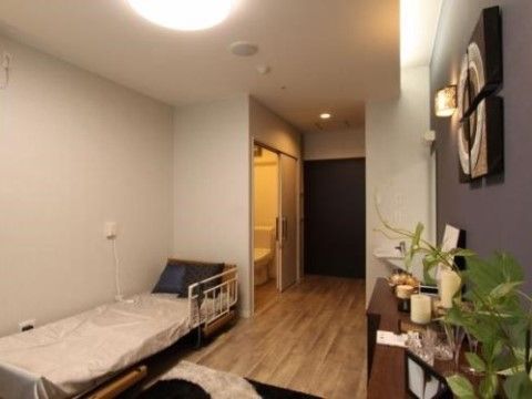 ベッドと収納家具、絨毯が敷かれており、個室のトイレがある居室