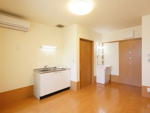 部屋の隅にミニキッチン、鏡付きの洗面台の設置されている居室