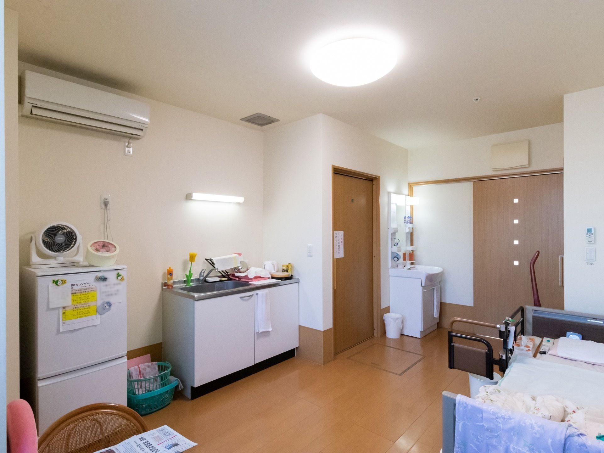 キッチンや洗面台が備え付けられているワンルームの居室で、トイレ前の床下には収納スペースが設けられている。