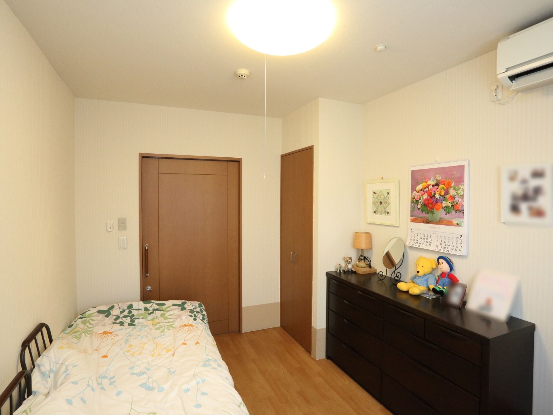 部屋にはベッドの他に、タンスやエアコンが設置されている。一人でゆっくり過ごすのには十分な空間である。